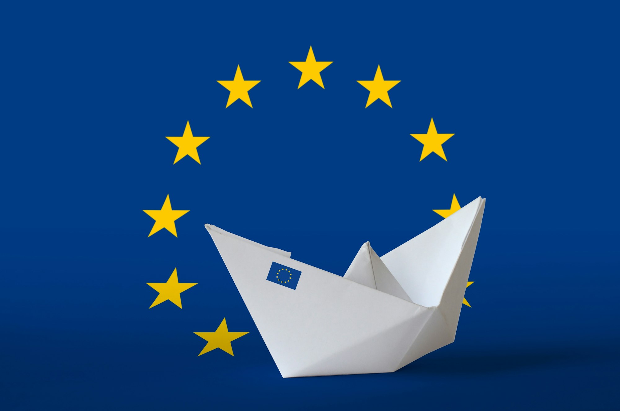 European union flag depicted on paper origami ship closeup. Oriental handmade arts concept